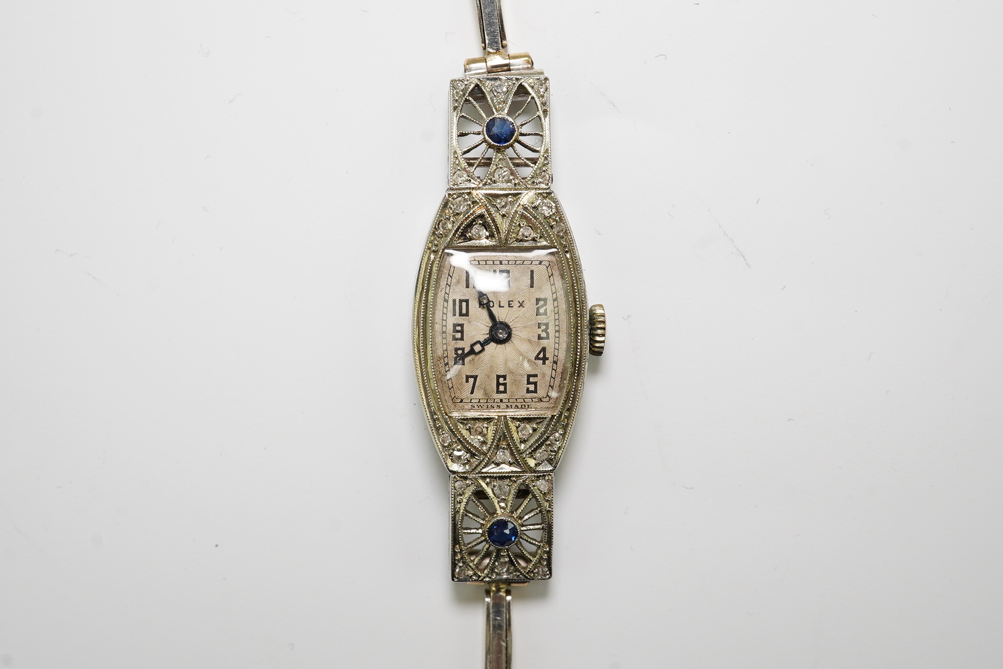 A lady's 1930's Art Deco pierced 18ct gold, sapphire and diamond set Rolex manual wind cocktail watch, on an 18ct gold and platinum expanding bracelet